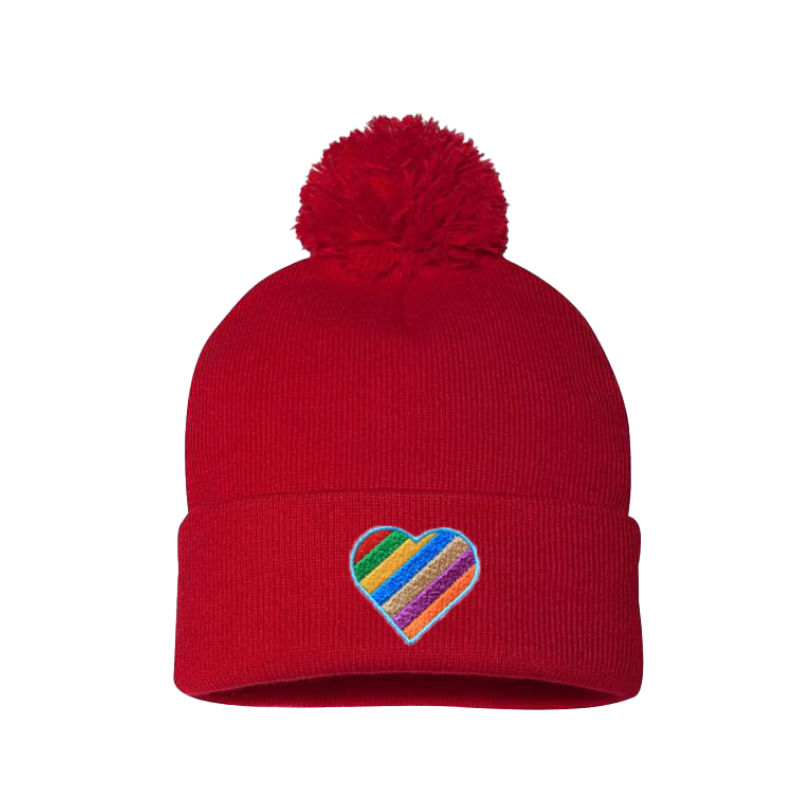 Red cuffed beanie with a pom pom. It has a heart embroidered with the LGTB colors on the cuff