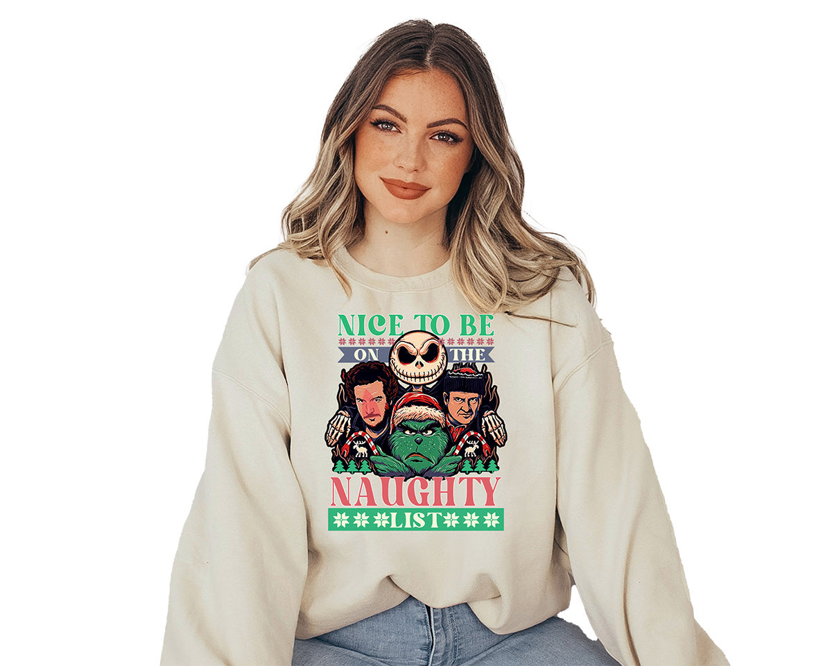 Young lady wearing a sand crewneck with a large screen printed of four Christmas characters. The grinch, Jack Skellington, Marv and Harry from home alone movie and a text Nice to be naughty.