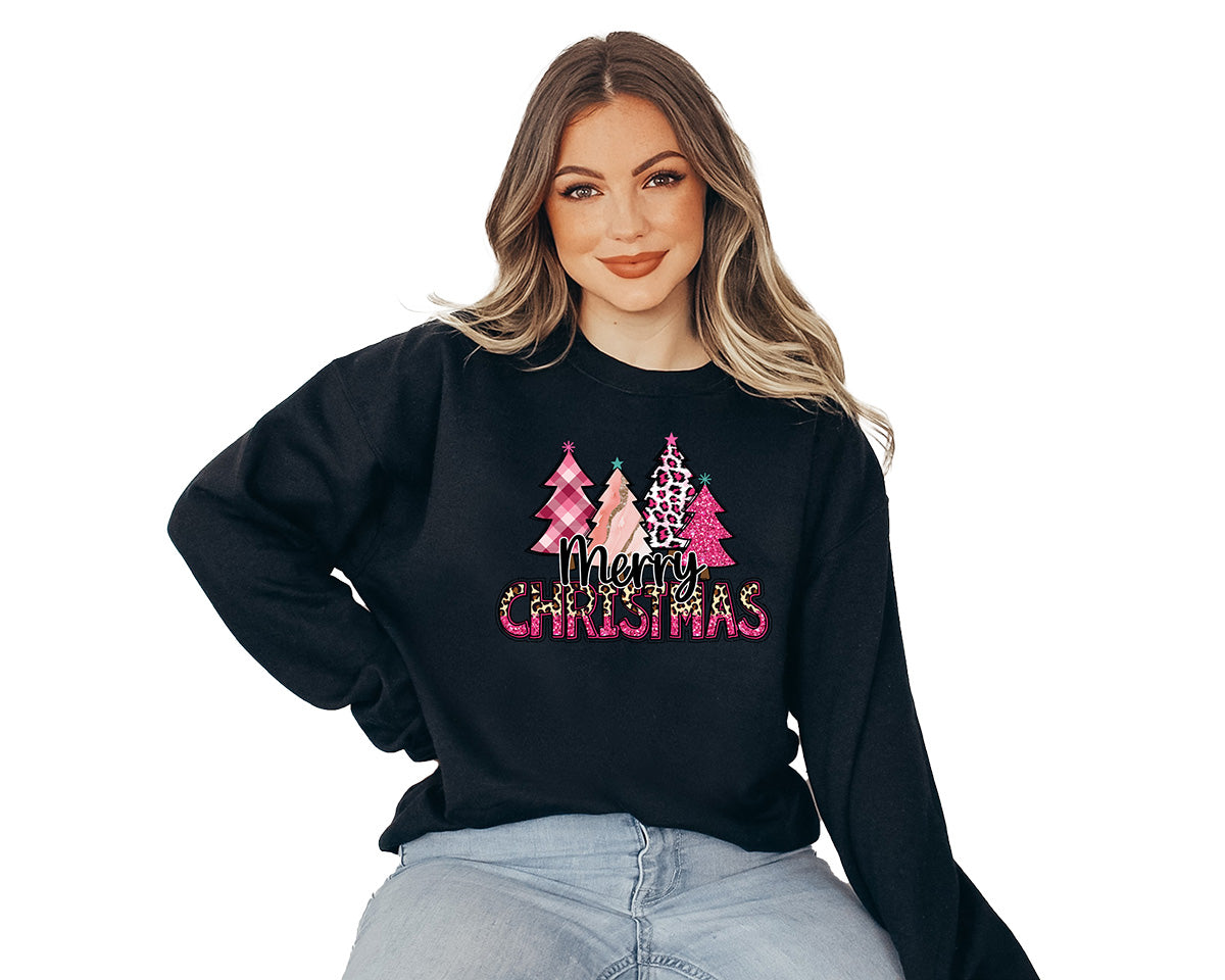 Young lady wearing a black sweater with a big screen printed on the front. This one has four different pink Christmas trees and a text in black Merry and Christmas in pink and cheetah colors.