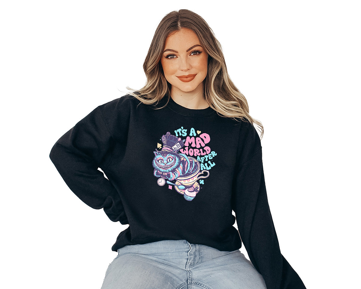 Young lady wearing a black crewneck sweatshirt with a screen printed. A big colorful smiley cat with a text it is a mad world after all