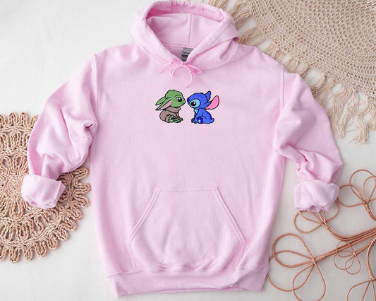 Embroidered baby pink hoodie of Yoda and Stich sitting and looking at each other