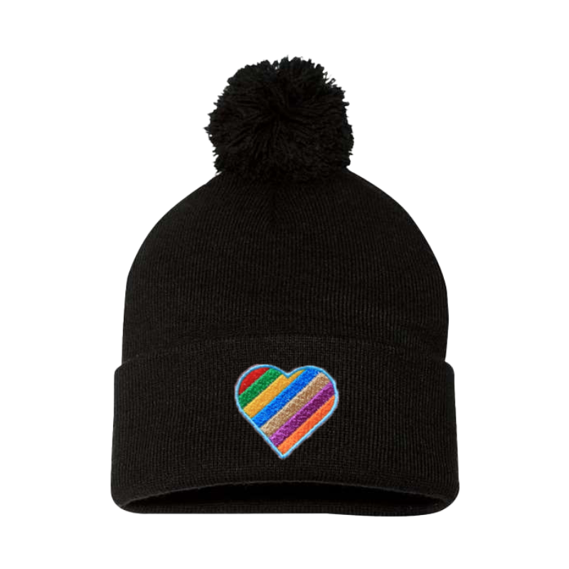 Black cuffed beanie with a pom pom. It has a heart embroidered with the Pride colors on the cuff