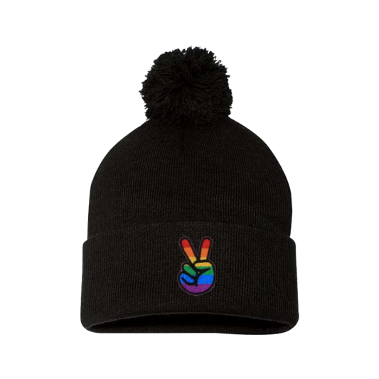 Black cuffed beanie with a pom pom. It has embroidered the sign of peace on the cuff with the Pride colors