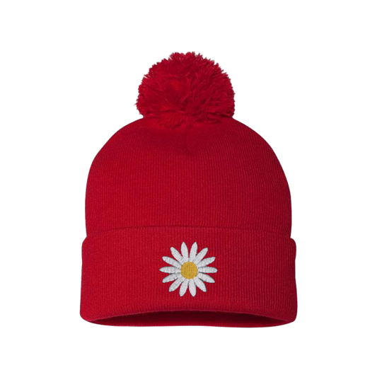 Red cuffed beanie with a Pom Pom. It has a white embroidered daisy